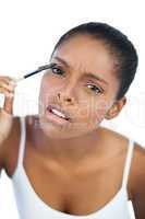 Beautiful woman putting mascara on her eyelash