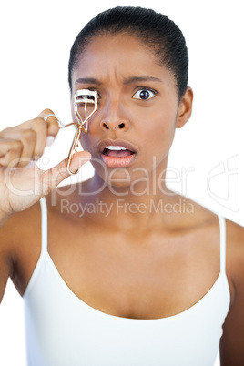 Shocked woman using curler for her eyelash