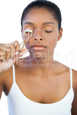 Young woman using curler for her eyelash