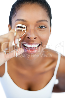 Happy woman using curler for her eyelash