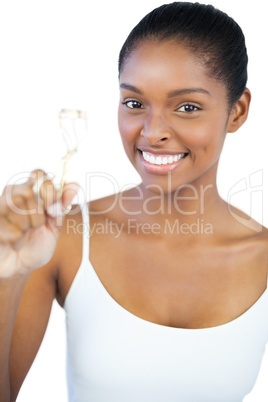 Smiling woman looking at her eyelash curler