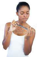 Serious young woman using nail file