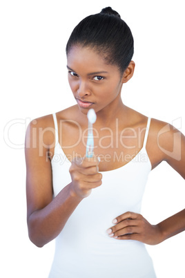 Woman pointing at camera with her toothbrush