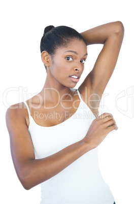 Woman putting deodorant on her armpit
