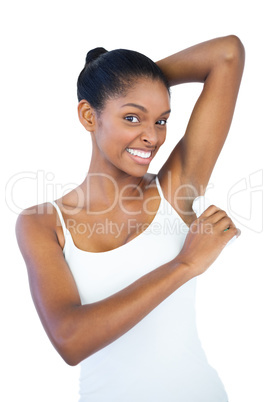 Smiling woman putting deodorant on her armpit