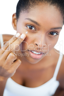 Pretty woman putting moisturizer on her face