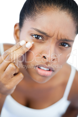 Unsmiling woman putting moisturizer on her face