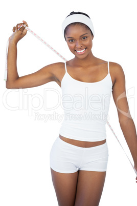 Happy woman holding measuring tape