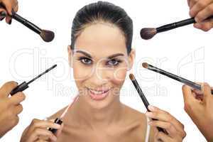 Beautiful woman encircled by make up brushes