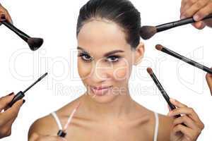 Sexy woman encircled by make up brushes