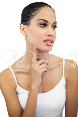 Beautiful woman with finger on her face looking away