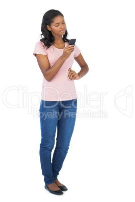 Young woman looking at her mobile phone with hand on hip