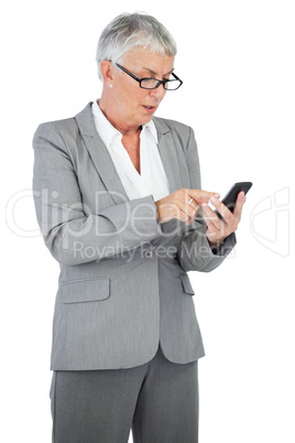 Businesswoman with glasses texting a message on her mobile phone