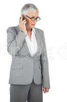 Unsmiling businesswoman calling someone with her mobile phone