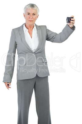 Unsmiling woman holding camera for taking picture