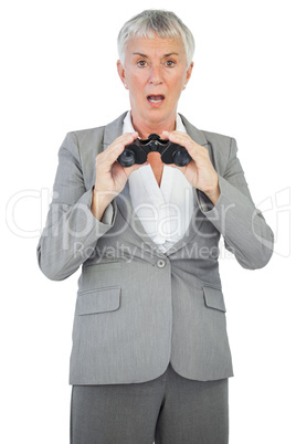 Shocked businesswoman holding binoculars