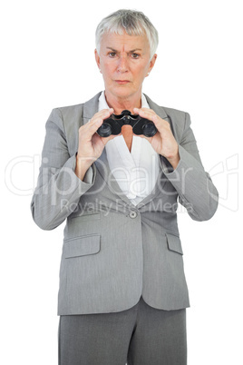 Unhappy businesswoman holding binoculars