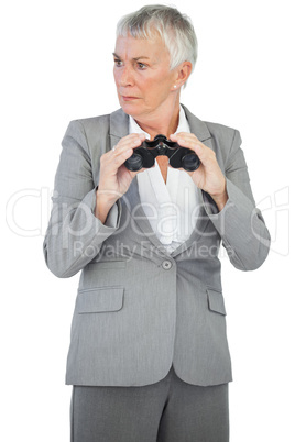 Unsmiling businesswoman holding binoculars