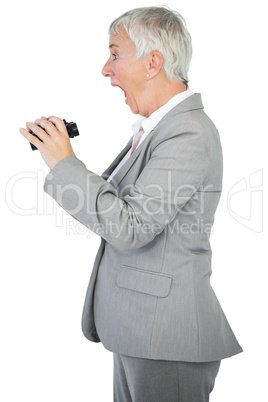 Surprised businesswoman holding binoculars