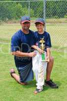 Father and son baseball player with trophy.