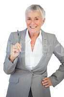 Businesswoman with hand on hip holding pen