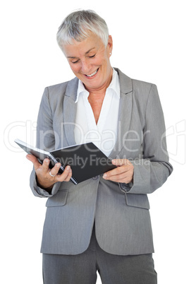 Smiling businesswoman reading notepad Smiling businesswoman reading notepad