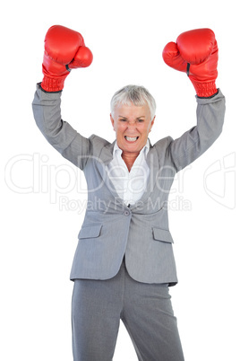 Businesswoman wearing boxing gloves and raising her arms