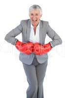 Happy businesswoman wearing boxing gloves