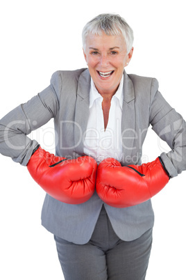 Cheerful businesswoman wearing boxing gloves