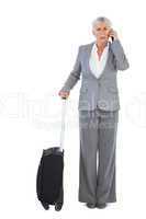 Serious businesswoman with her luggage and calling someone