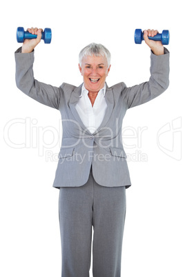 Smiling businesswoman holding dumbbells