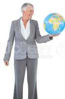 Smiling businesswoman holding and looking at globe
