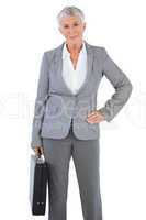 Businesswoman holding briefcase and putting her hand on hip