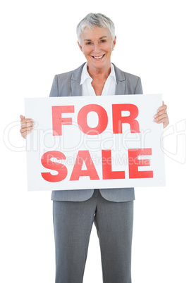 Smiling estate agent holding for sale sign