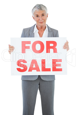 Estate agent holding for sale sign