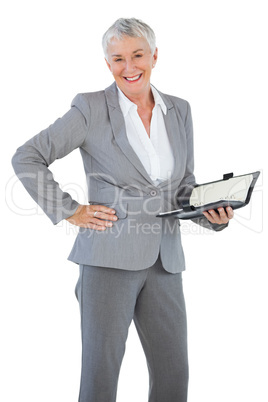 Smiling businesswoman holding diary with her hand on hip