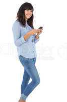Happy brunette with her mobile phone texting a message
