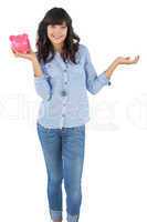 Young woman holding her piggy bank