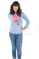 Young woman showing her piggy bank