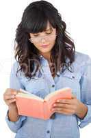 Young woman wearing glasses and reading her book
