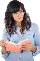 Young woman wearing glasses and thinking about her book