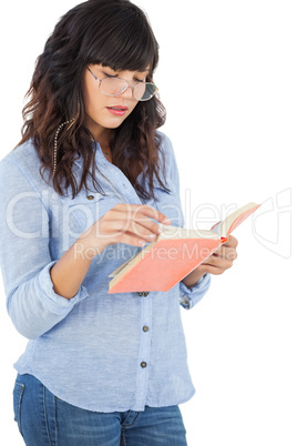 Brunette wearing glasses and reading her book