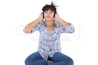 Young woman sitting on the floor listening to music