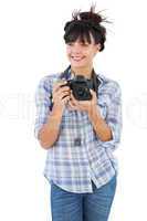 Happy young woman holding camera for taking picture