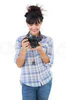 Smiling young woman holding camera for taking picture