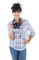 Smiling young woman with hand on her hip taking picture