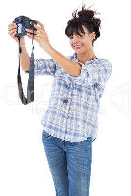 Smiling brunette taking picture with her camera