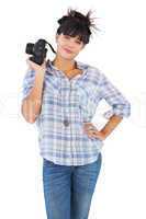 Happy beautiful woman with her hand on hip and holding camera