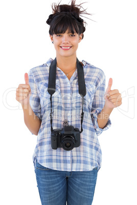 Woman with camera showing  thumbs up