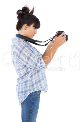 Concentrated young woman taking picture with her camera